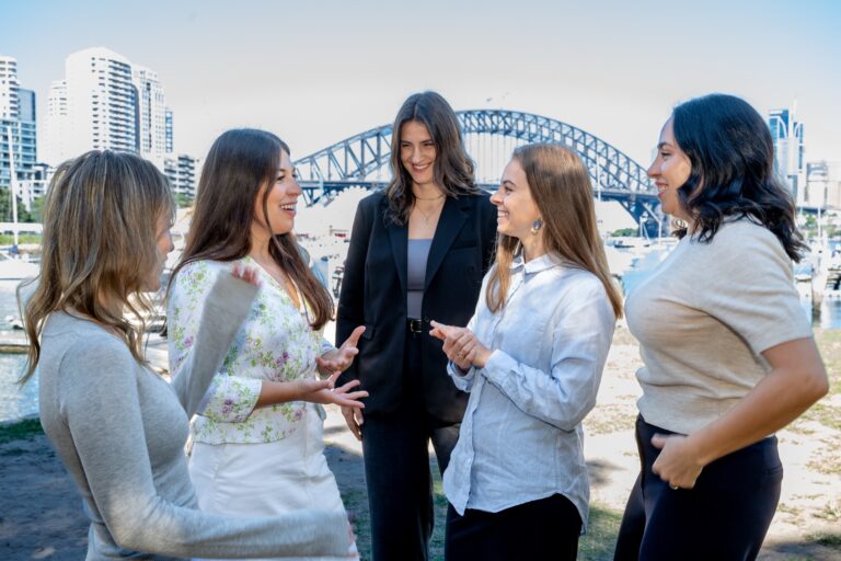 Five members of the Palin team talking together in front of the Sydney Harbour Bridge